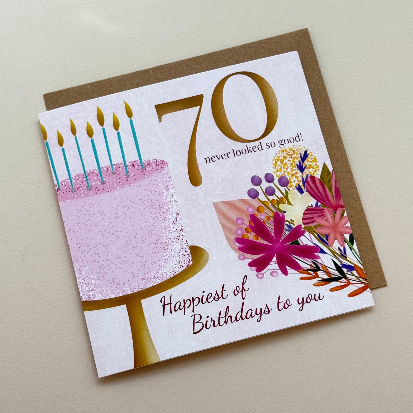 70th birthday card with floral design and cake illustration on a plain background