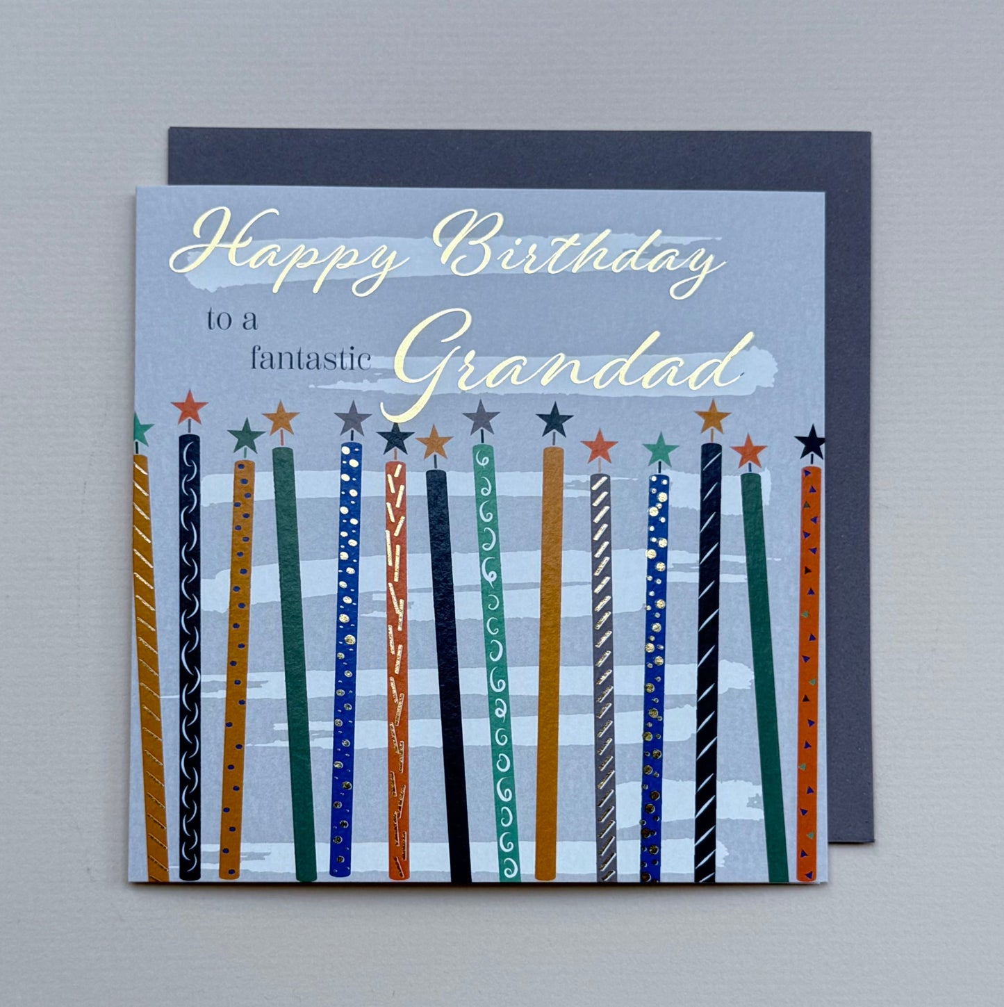 Birthday card for a grandad with colorful candles on a gray background