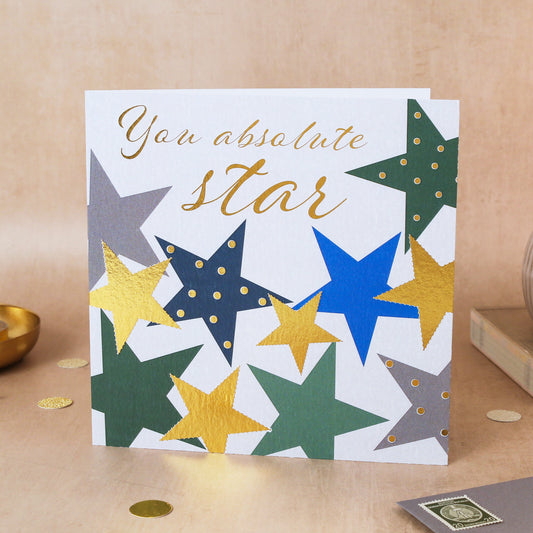 Card with star design and 'You absolute star' text on a beige surface