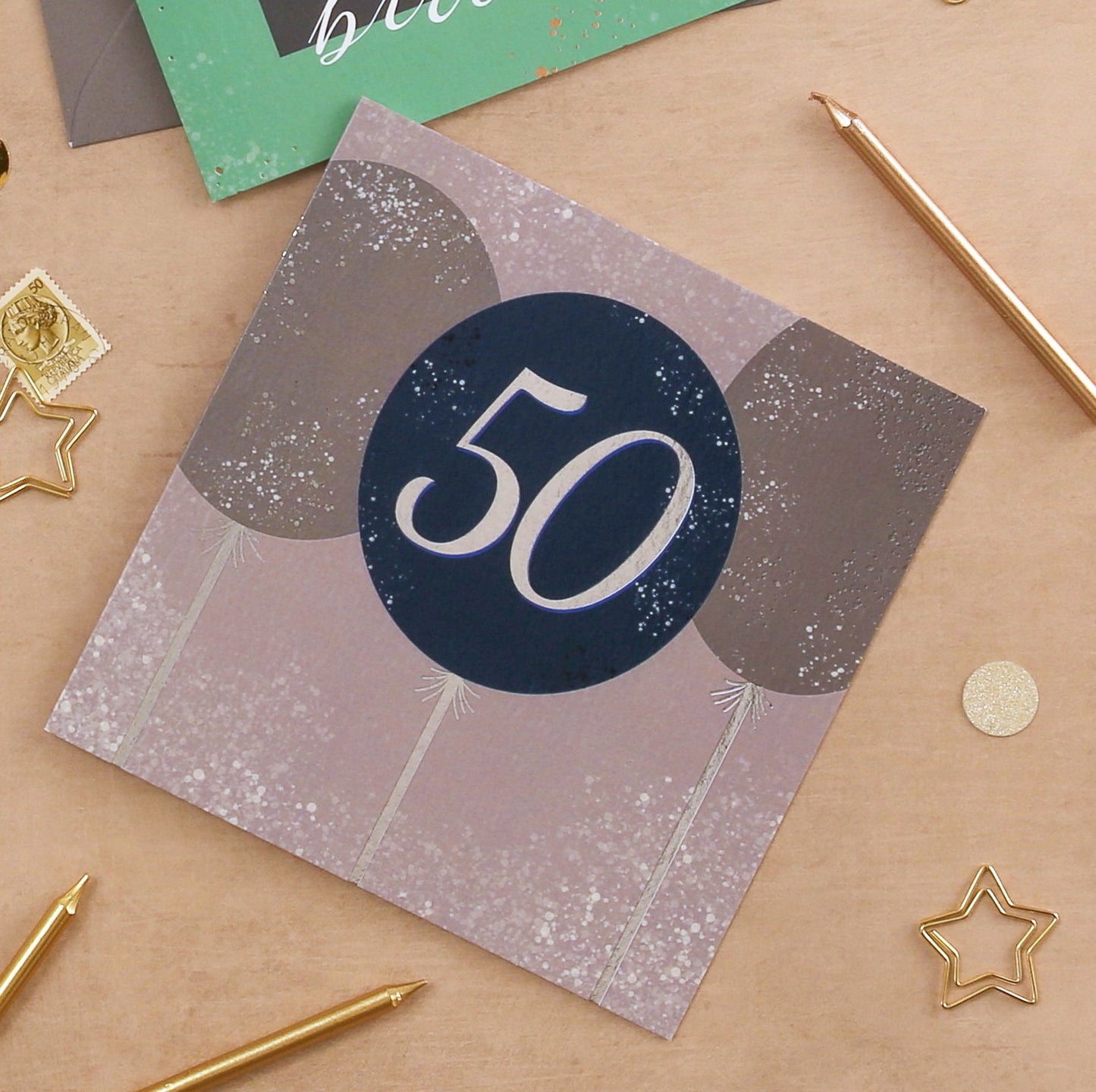 Card with number 50 on a beige surface with decorative items
