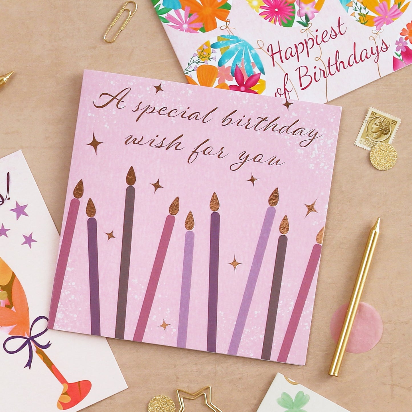Birthday card with candles on a table with other cards and stationery items.