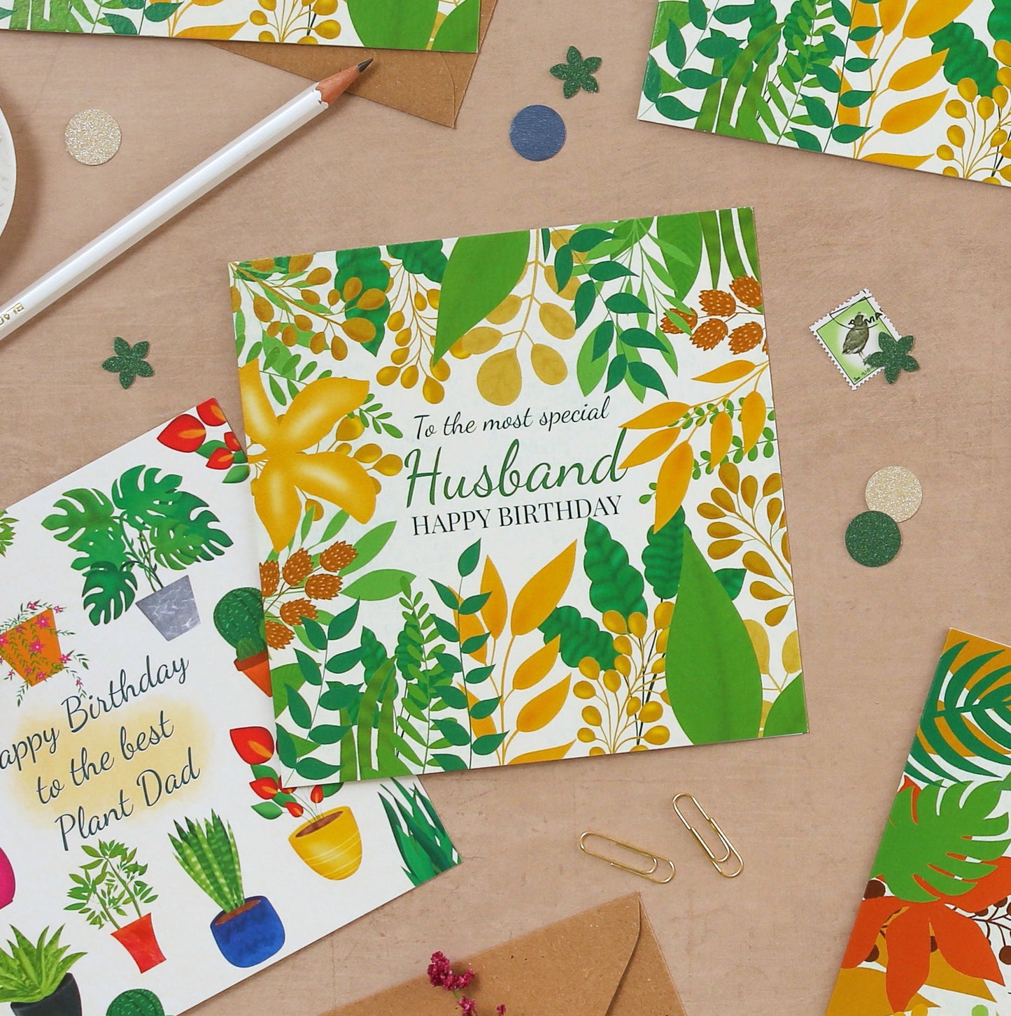 Collection of colorful greeting cards with various designs on a wooden surface.