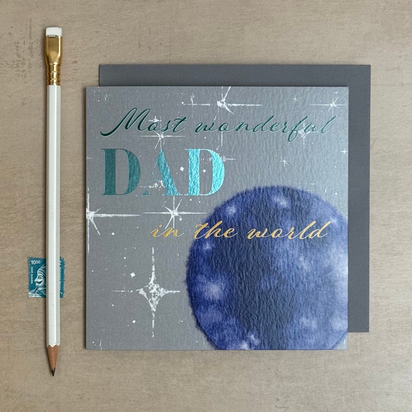Greeting card for Father's Day with 'Most wonderful Dad in the world' text on a textured surface.