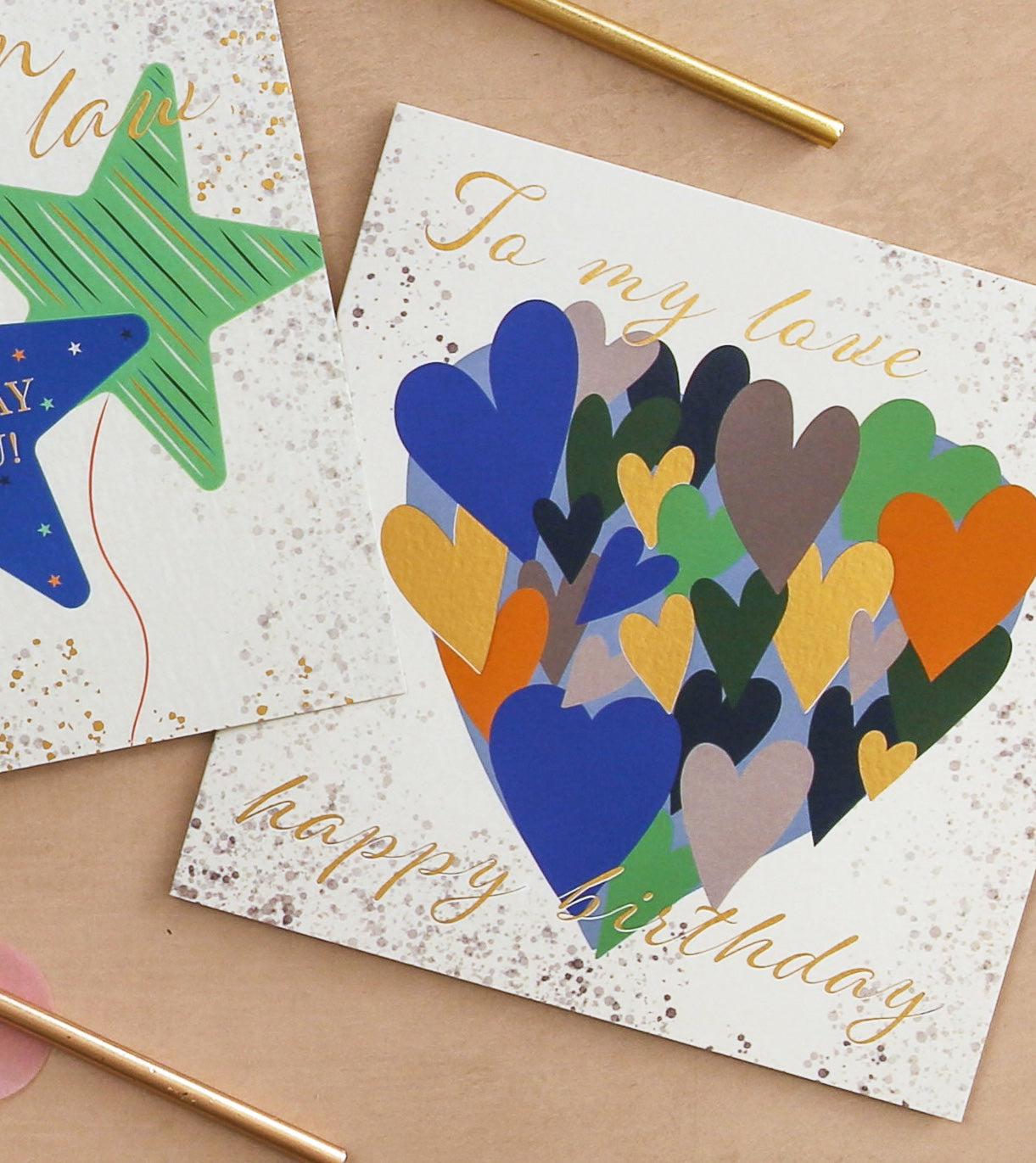 Colorful heart-shaped birthday card on a beige surface with gold accents.