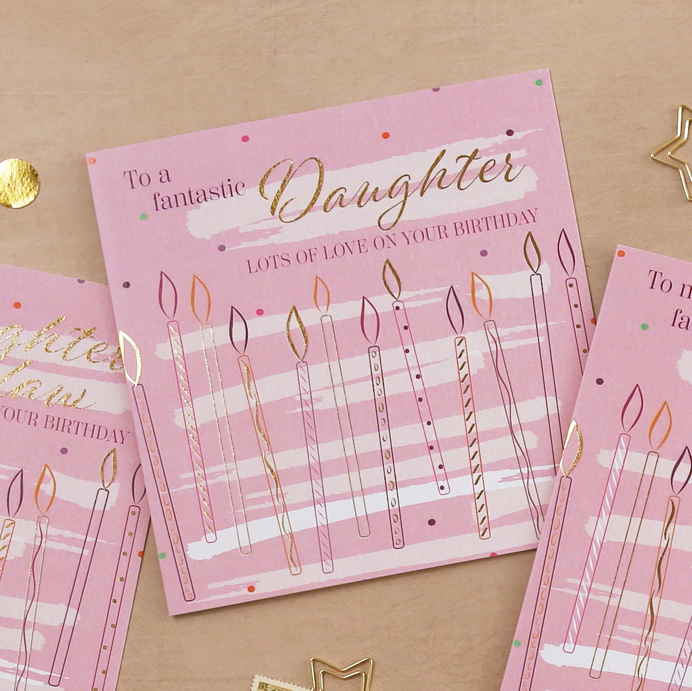 Pink birthday card for a daughter with candles and text on a beige background