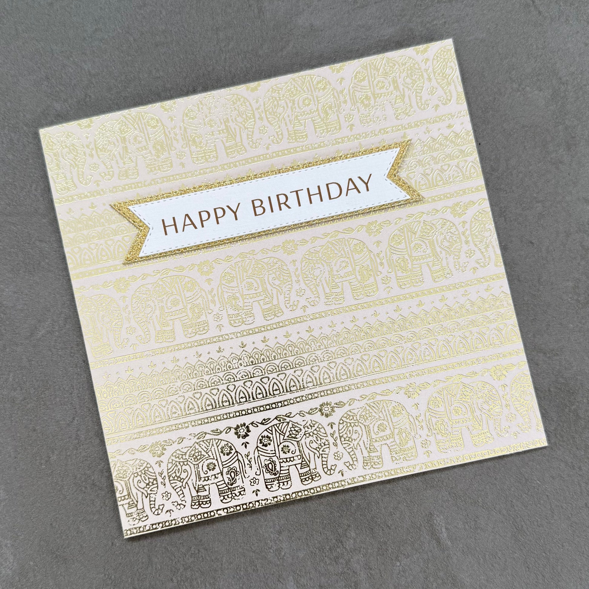 Greeting card with elephant pattern and 'Happy Birthday' text on a gray background