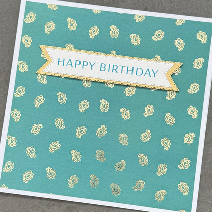 Birthday card with decorative patterns and 'Happy Birthday' text on a textured surface