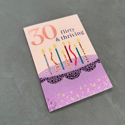 Greeting card with birthday cake design and candles on a gray background