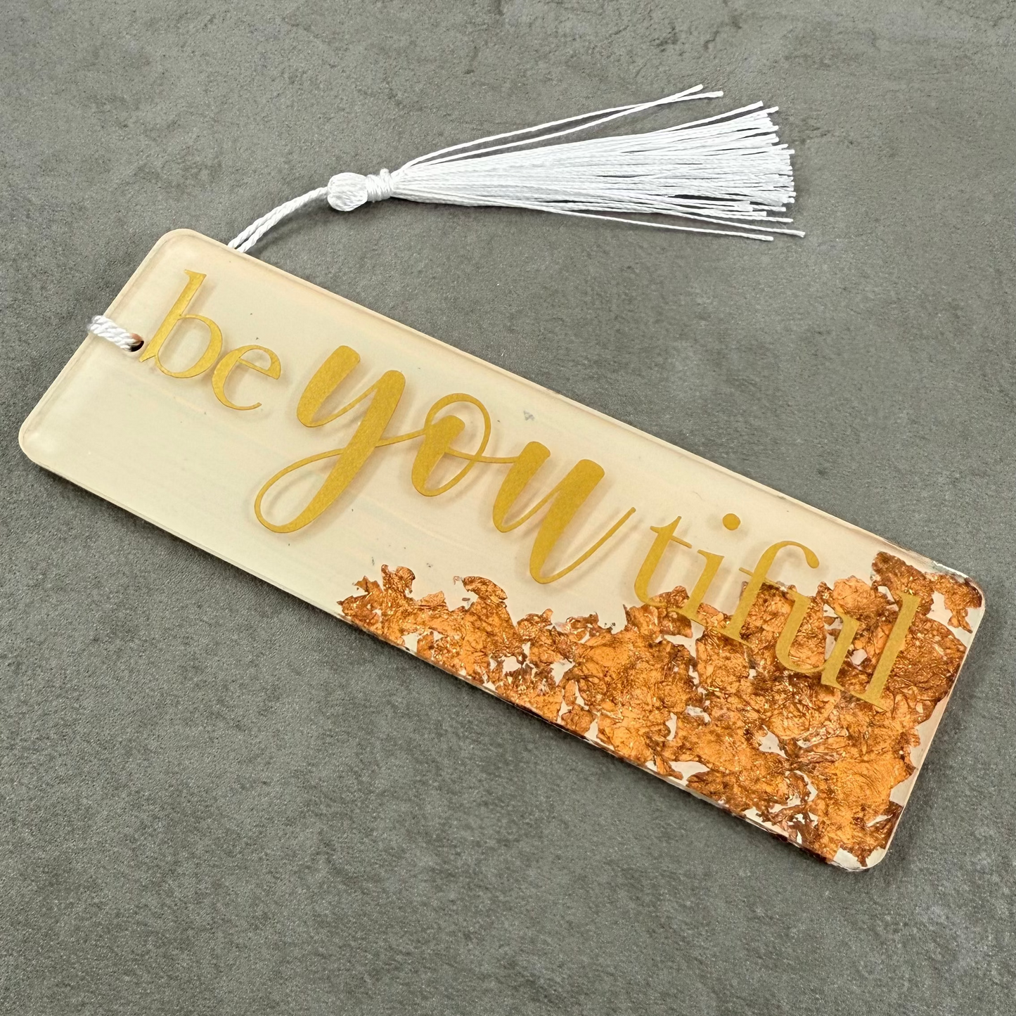 Bookmark with 'beyoutiful' text on a textured surface
