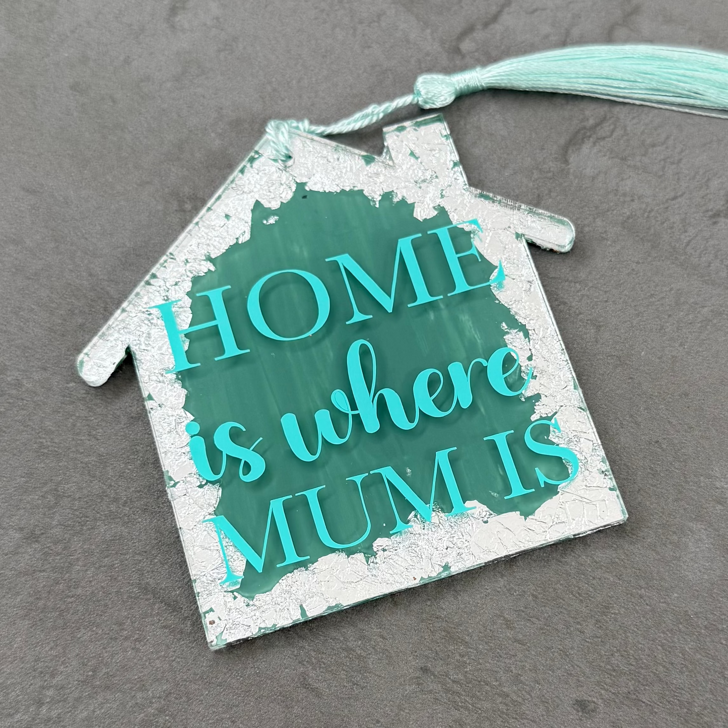 Decorative house-shaped sign with 'Home is where Mum is' text on a gray background