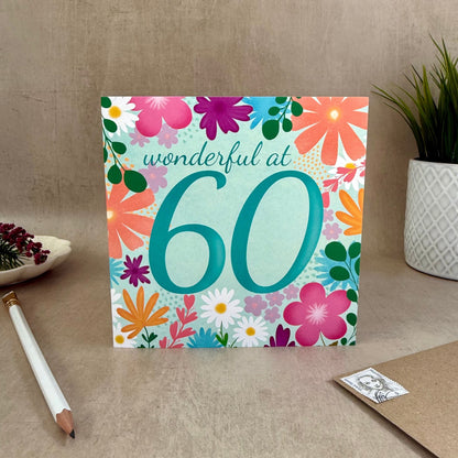 Greeting card with floral design and 'wonderful at 60' text on a neutral background
