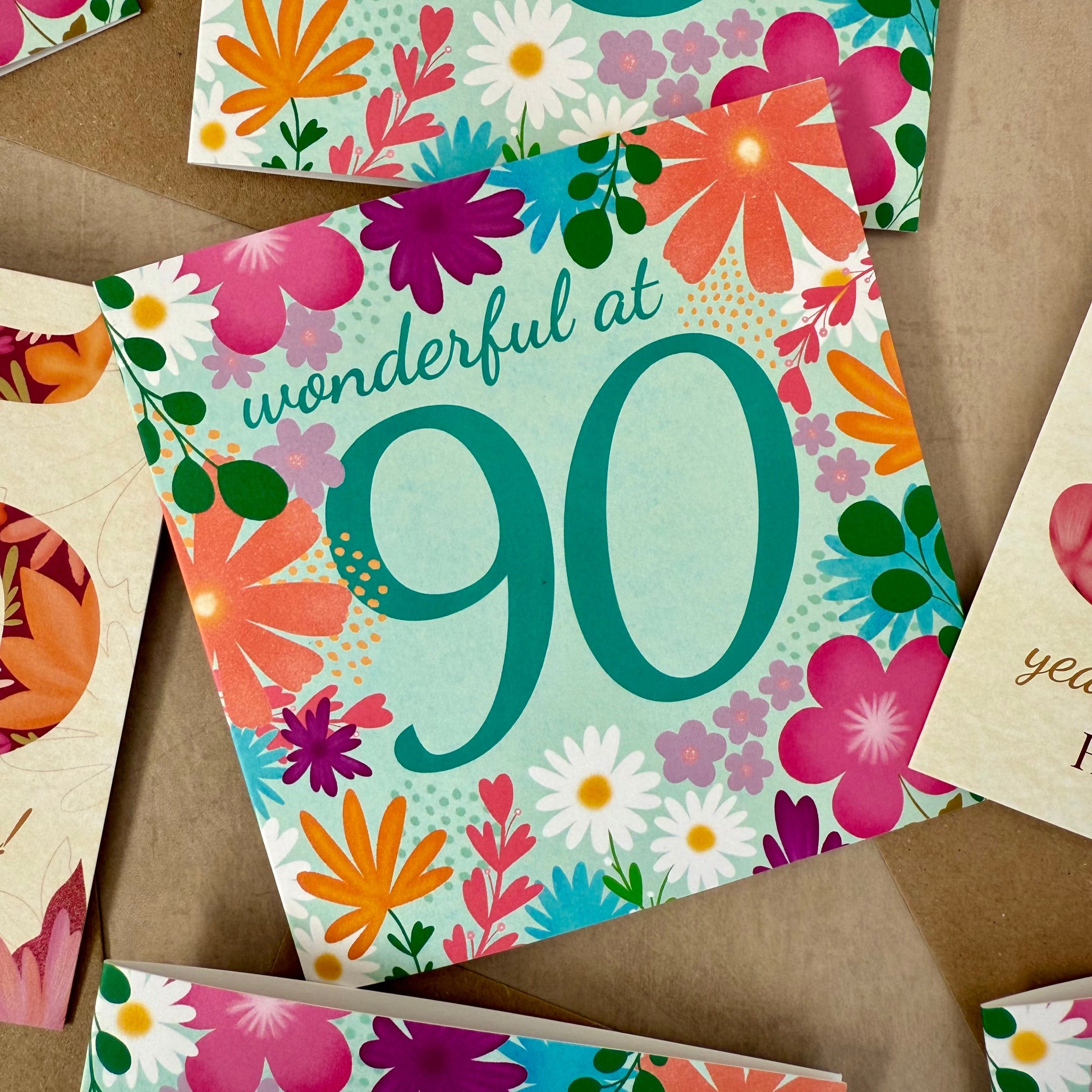 Colorful birthday card with floral design and text 'wonderful at 90' on a brown background