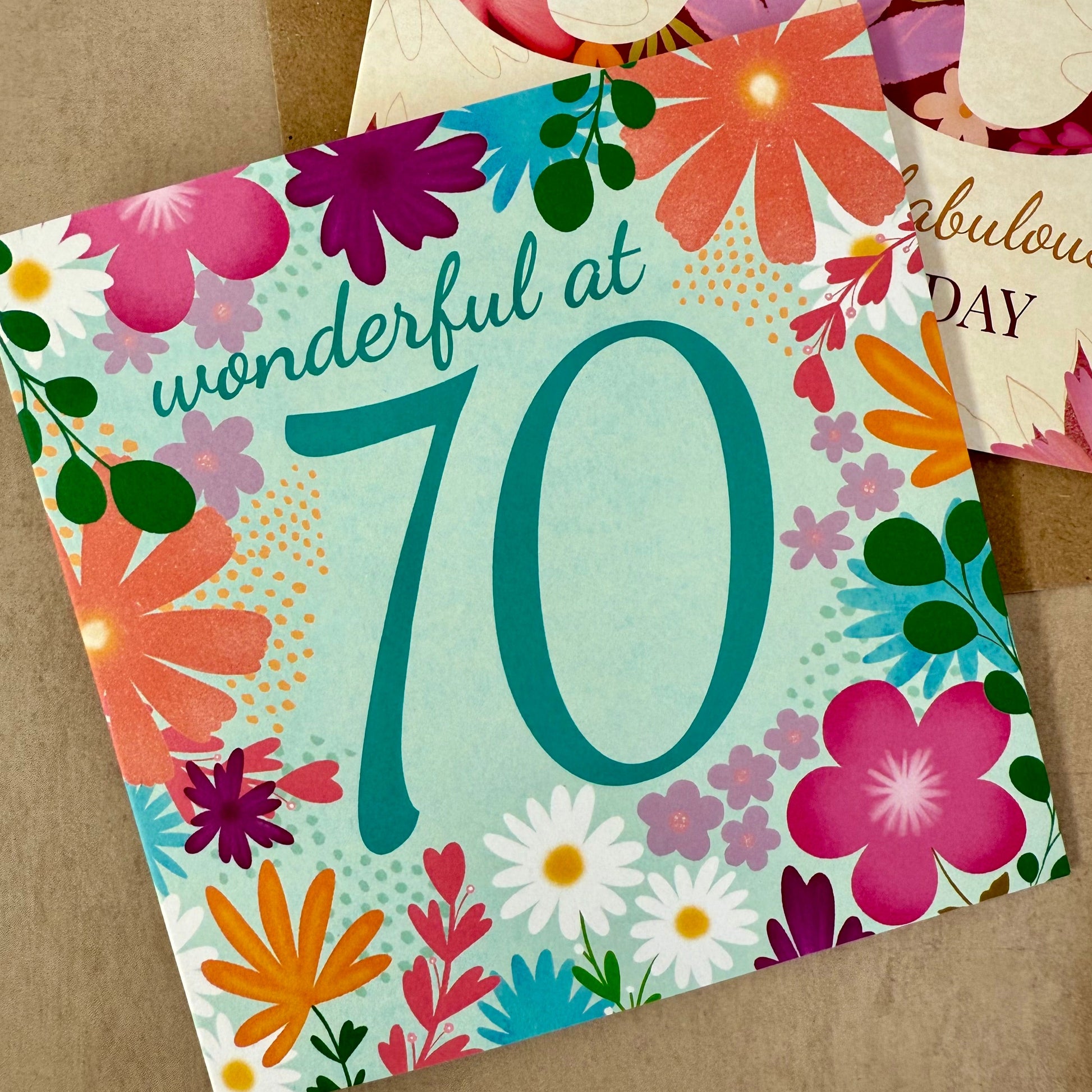 Colorful birthday card with flowers and 'wonderful at 70' text on a brown background