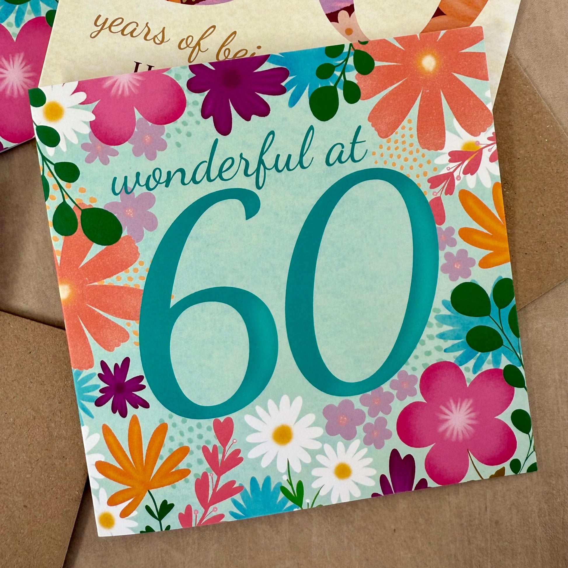 Floral-themed birthday card with 'wonderful at 60' text on a brown background