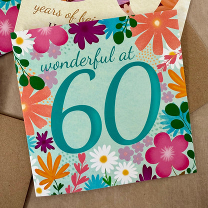 Floral-themed birthday card with 'wonderful at 60' text on a brown background