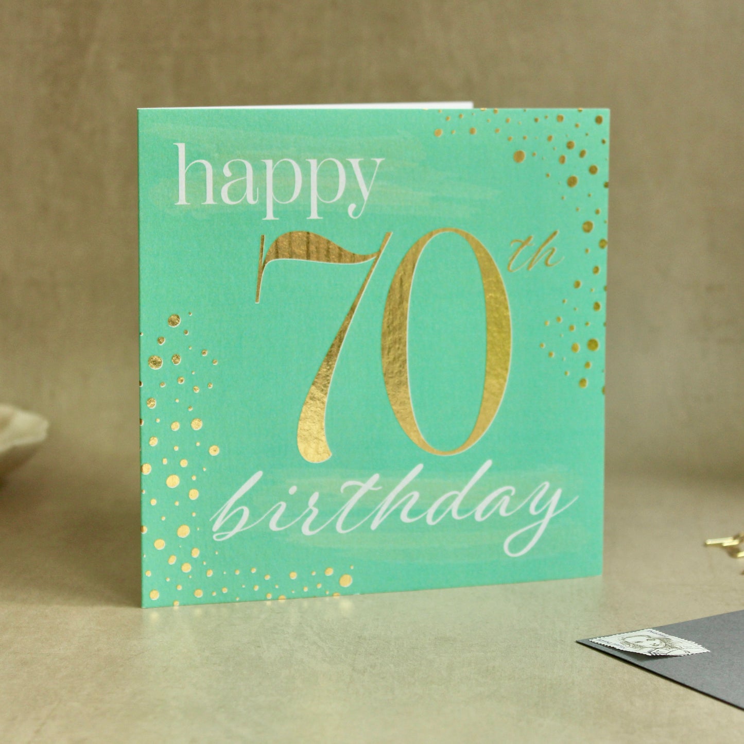 Green birthday card with gold text for a 70th birthday on a neutral background