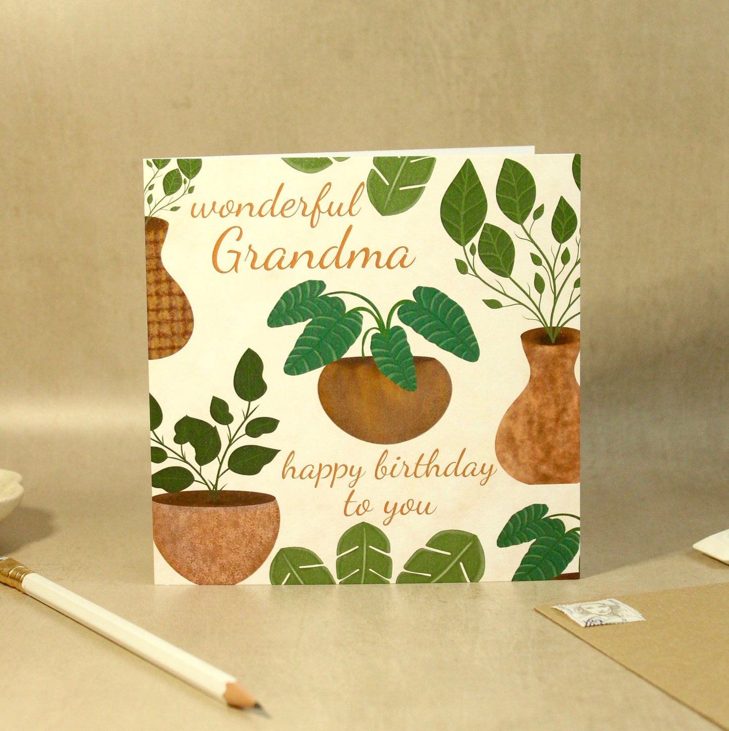 Greeting card with plant design and text on a beige surface