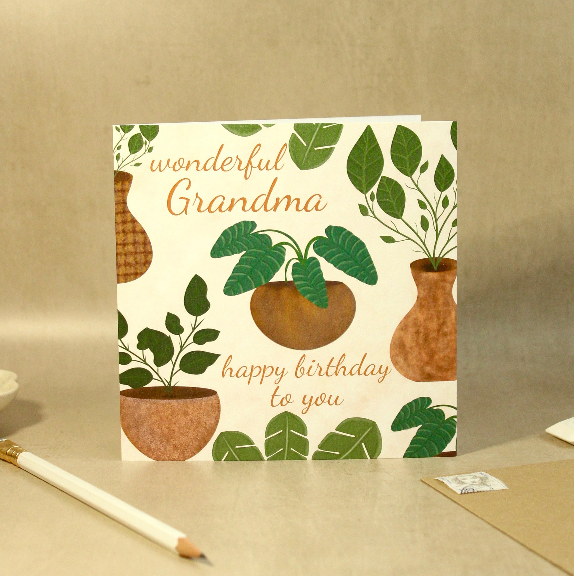 Greeting card with plant design and text on a beige surface