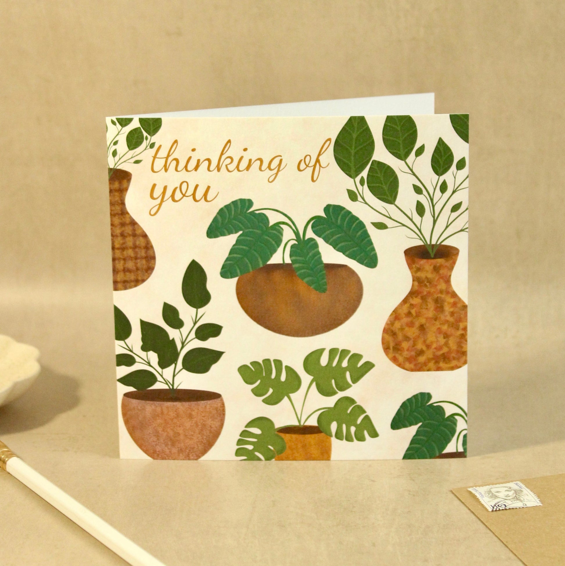 Greeting card with plant illustrations and 'thinking of you' text on a beige background