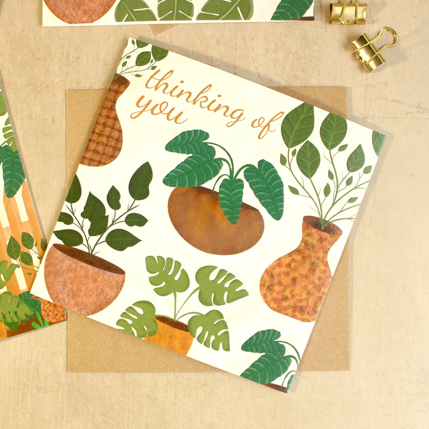 Greeting card with plant illustrations and 'thinking of you' text on a beige background