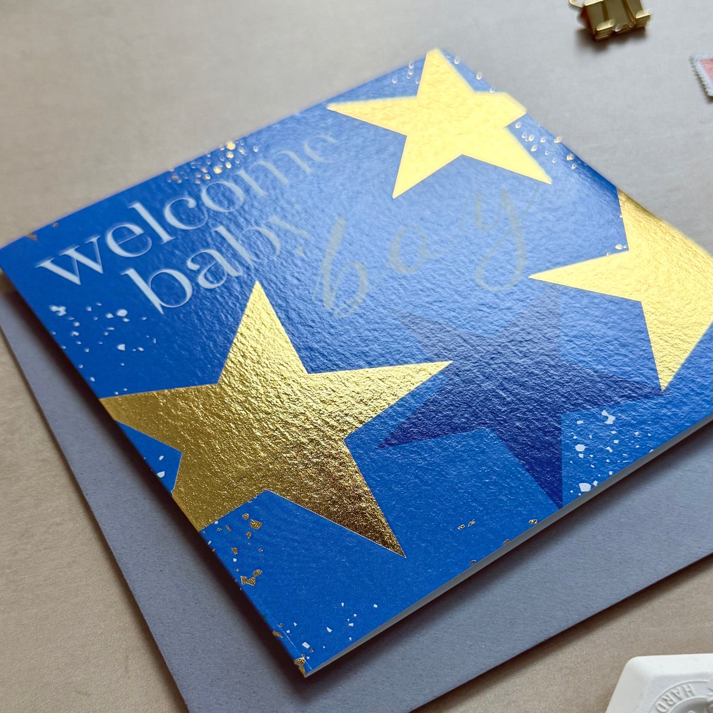Blue card with gold stars on a light gray surface