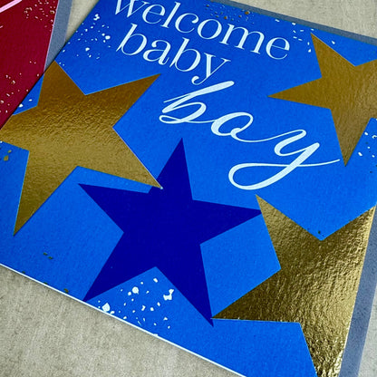 Card with 'welcome baby boy' text and star designs on a blue background