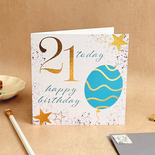 21st birthday card on a brown surface with decorative elements