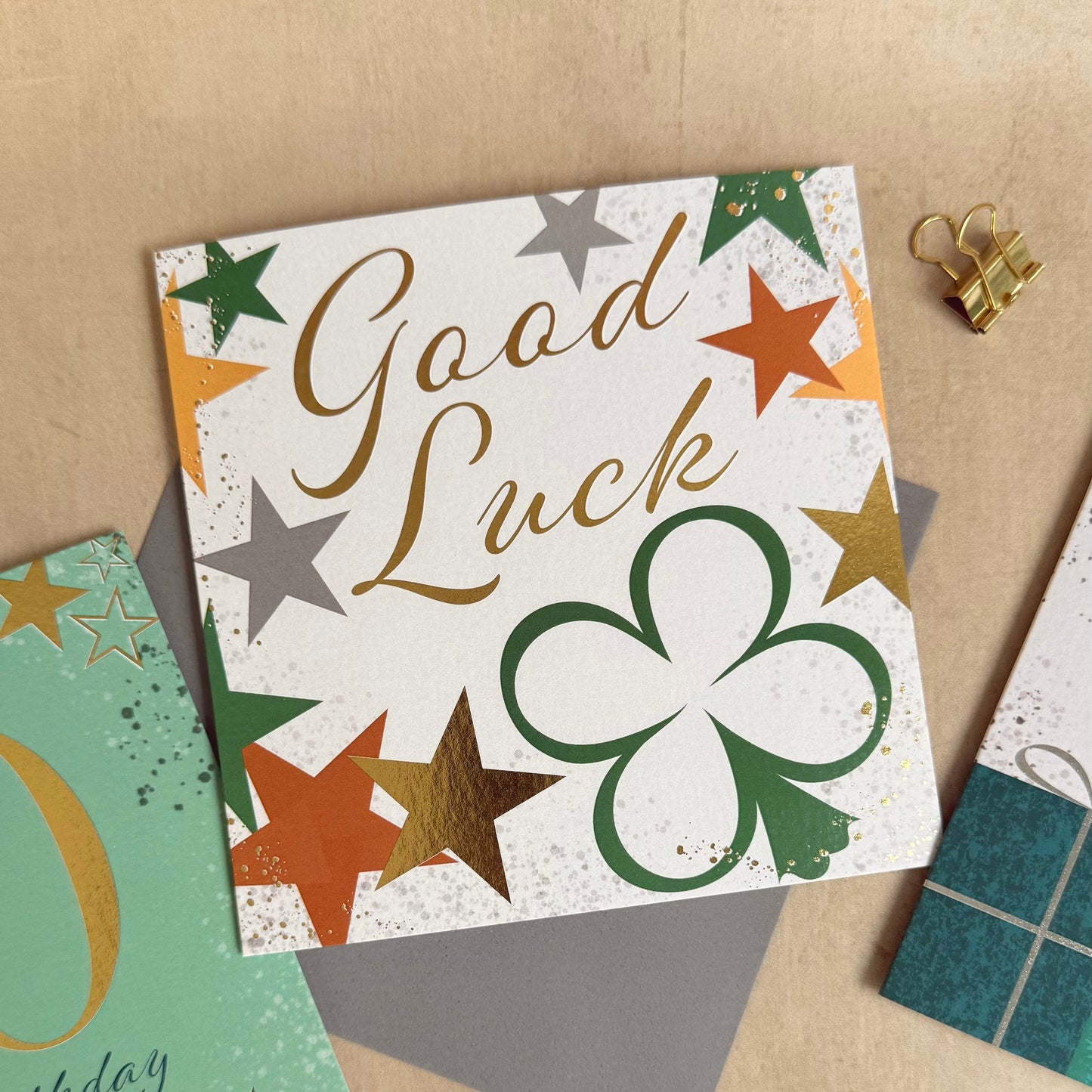 Collection of greeting cards with 'Good Luck' and other messages on a textured surface.