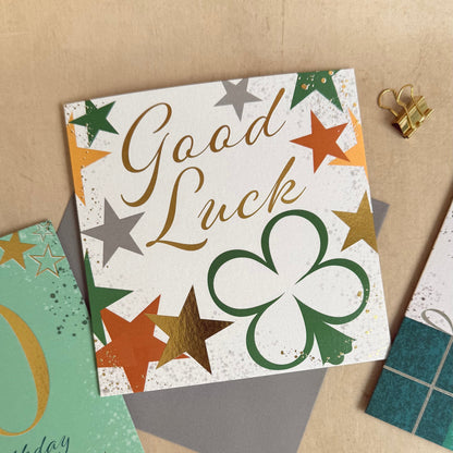 Collection of greeting cards with 'Good Luck' and other messages on a textured surface.