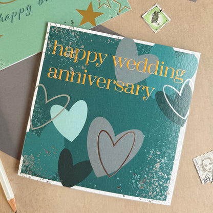 Collection of greeting cards with 'happy wedding anniversary' and '30 happy birthday' text on a textured surface.