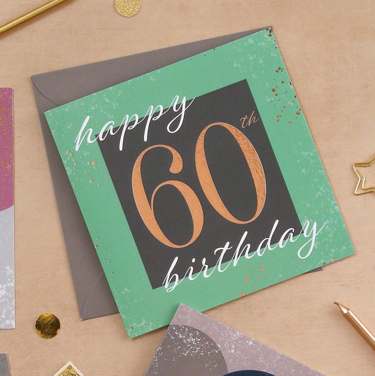 Happy 60th birthday card with gold text on a textured surface