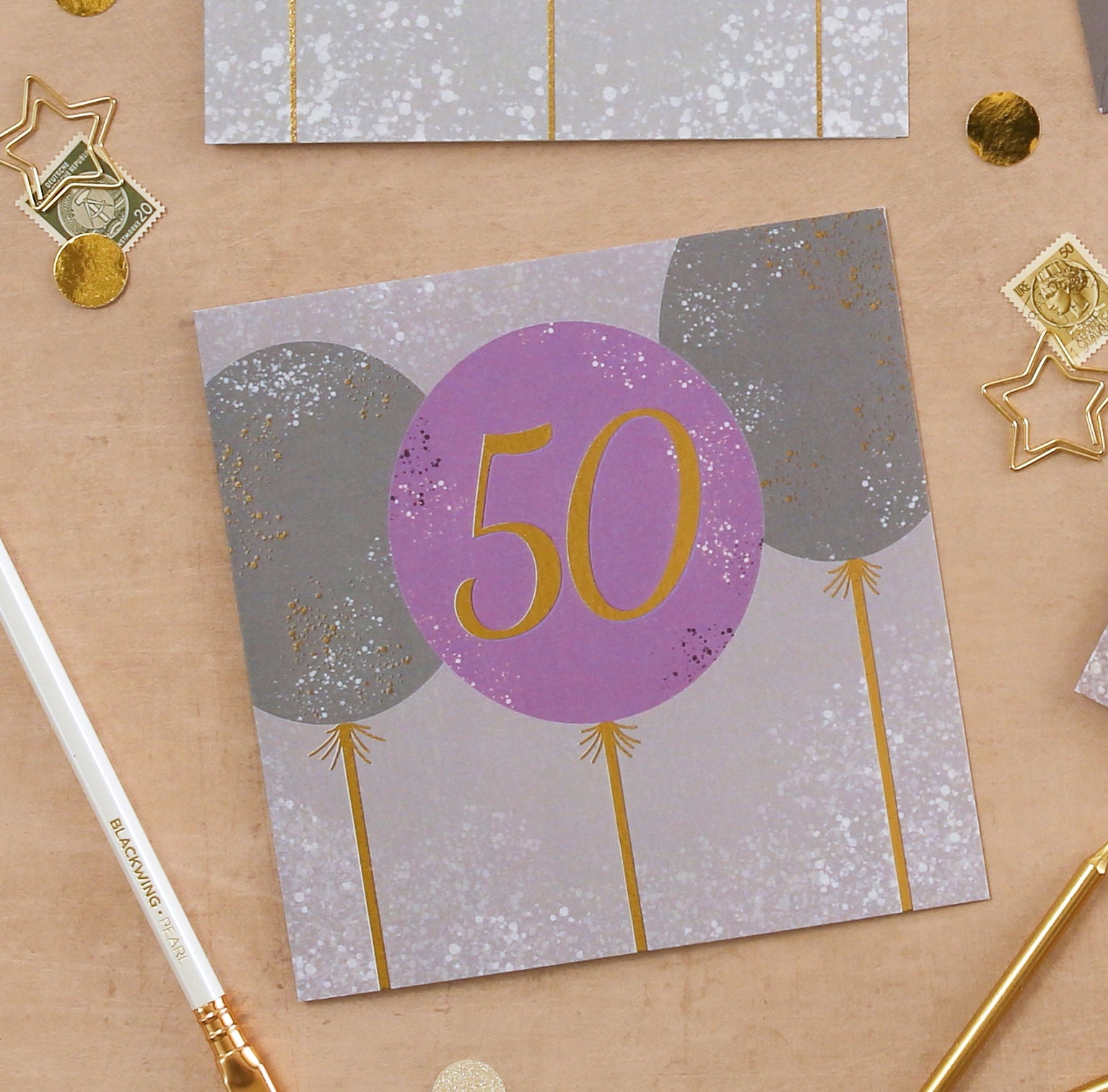 Greeting card with balloons and '50' on a decorative background