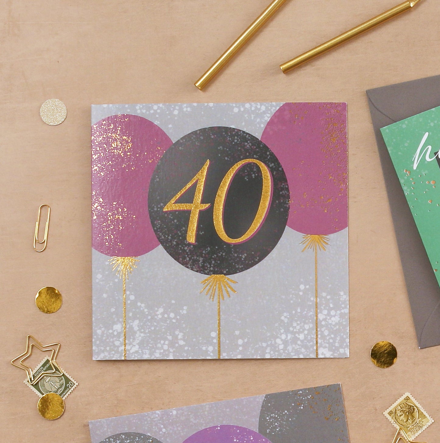 Four birthday cards for different ages on a brown background with decorative items.