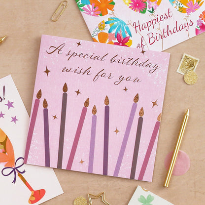 Birthday card with candles on a table with other cards and stationery items.