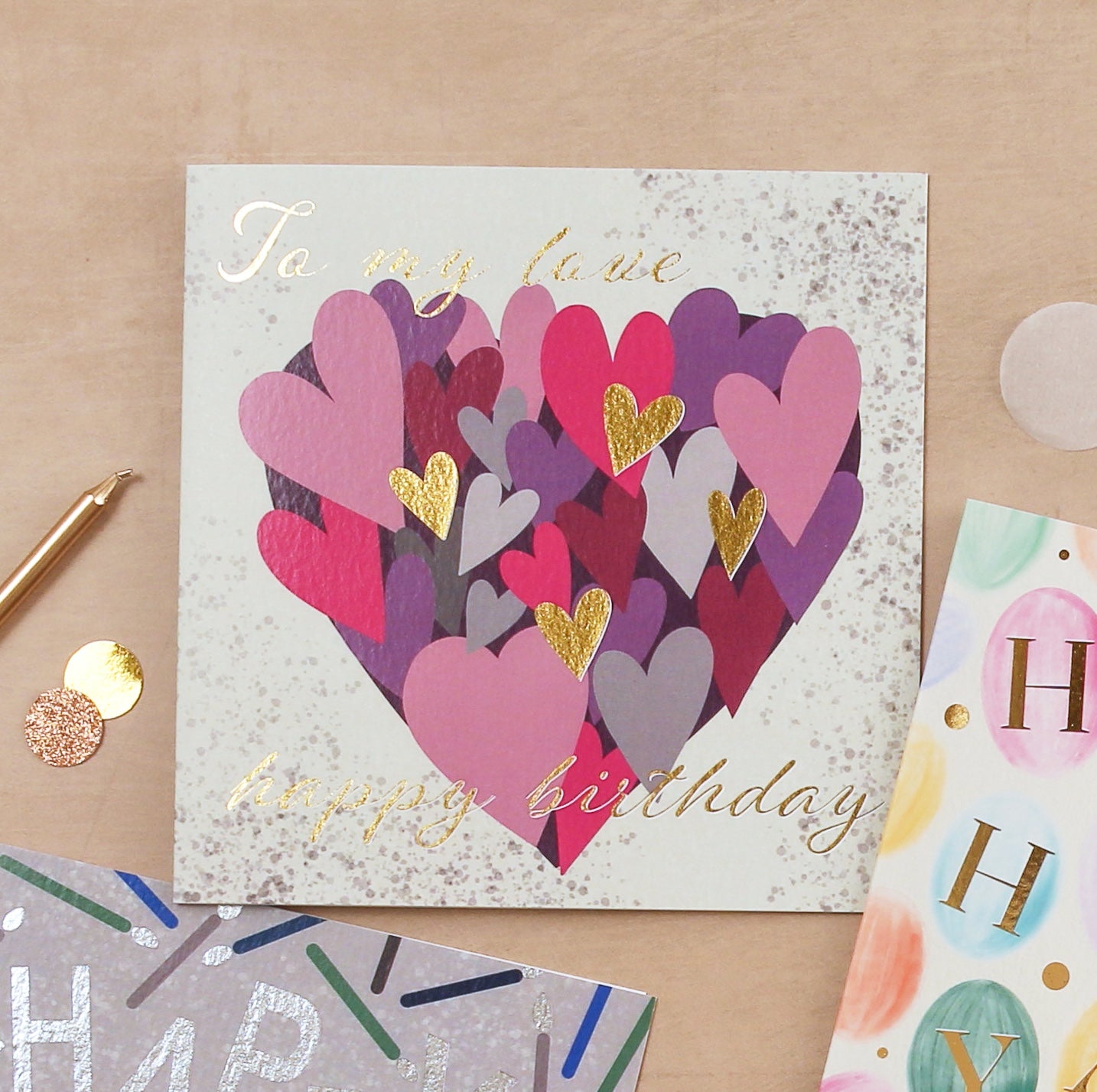 Birthday card with colorful heart design on a beige surface