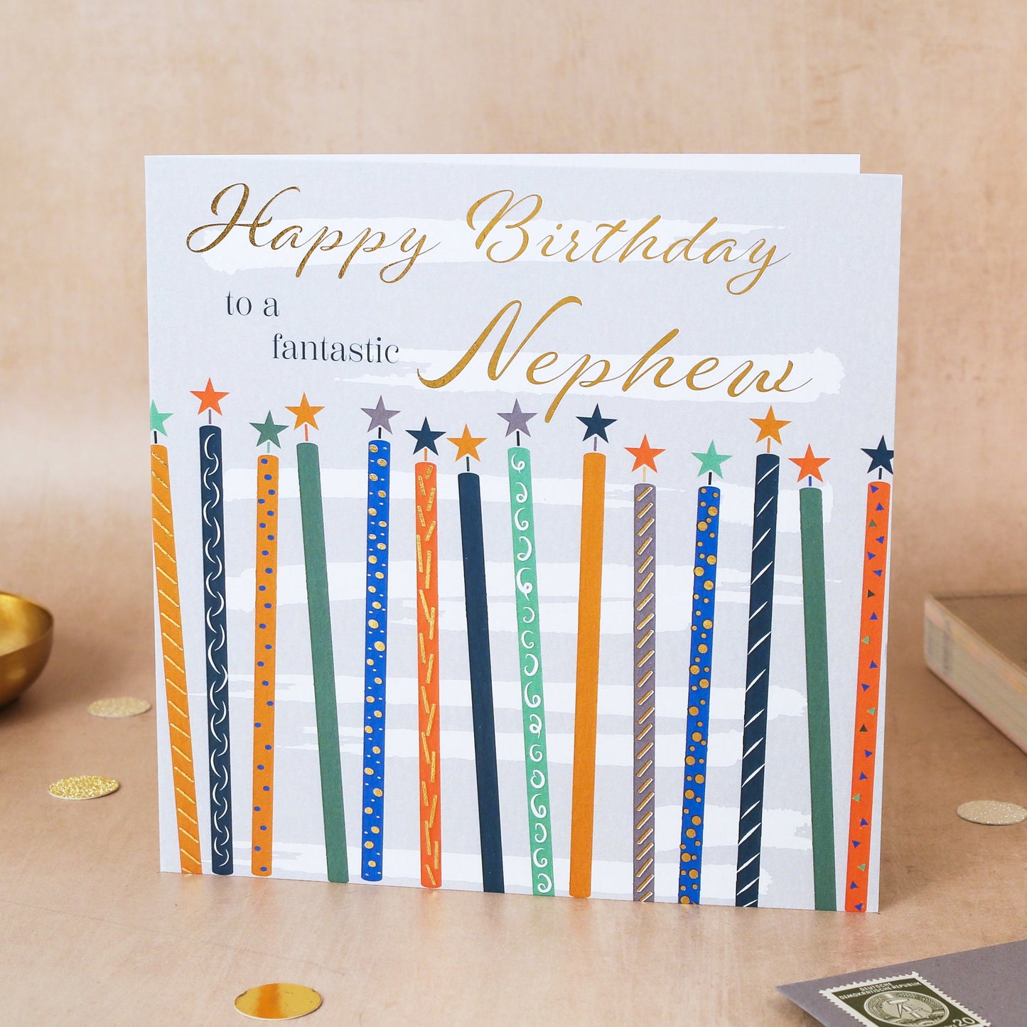 Birthday card for a nephew with colorful candles on a wooden surface.