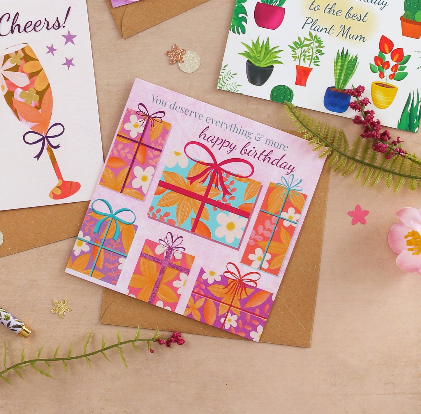 Colorful birthday card with gift boxes on a brown surface with decorative elements.