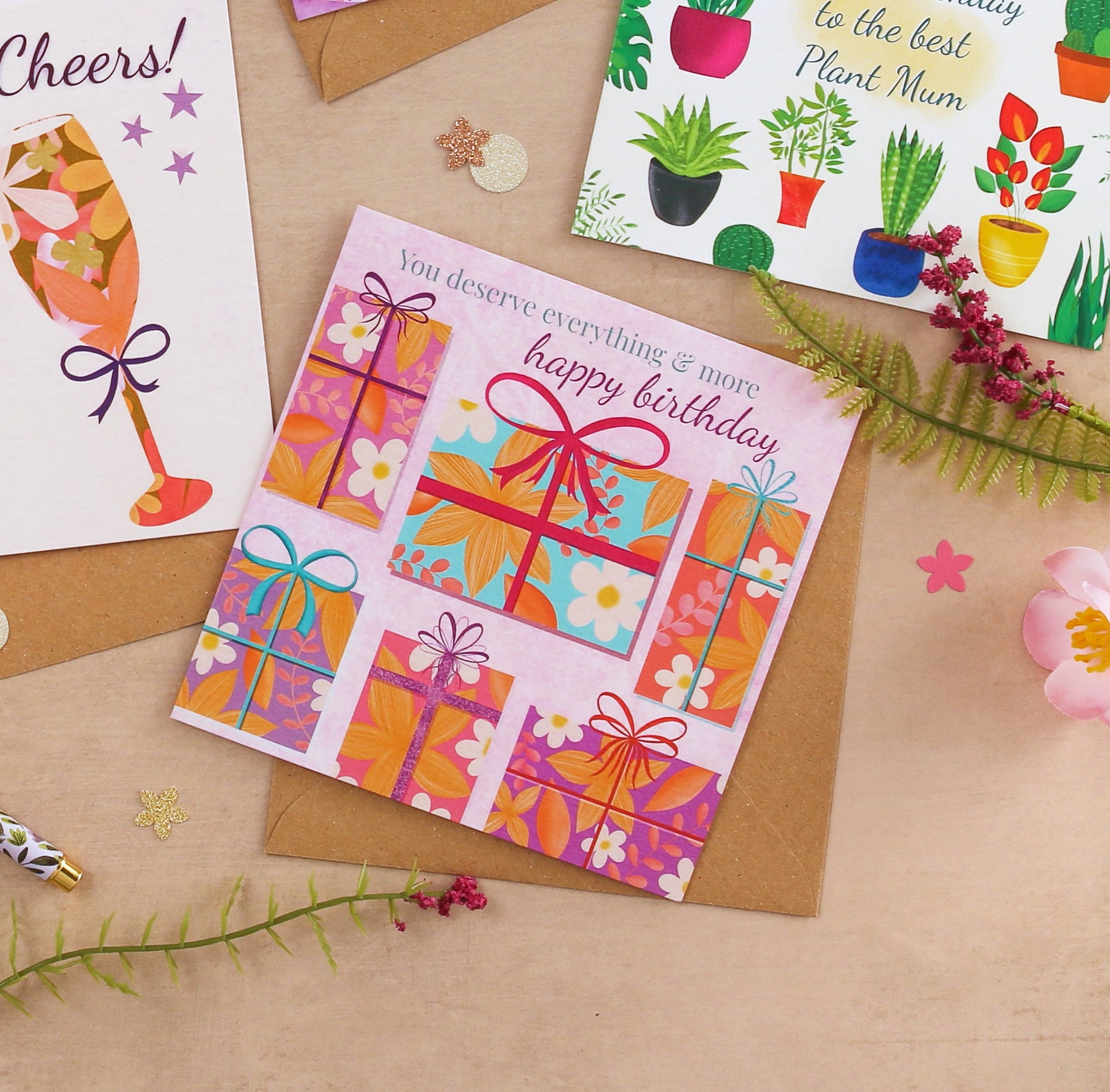Colorful birthday card with gift boxes on a brown surface with decorative elements.